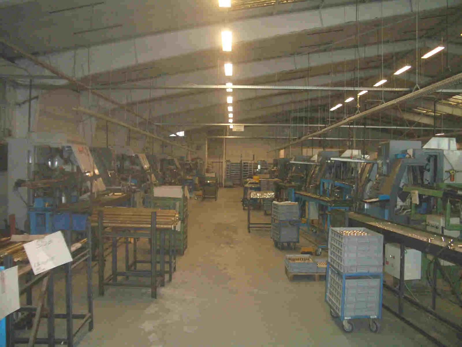 Produktionshalle mit Reihen von CNC-Drehmaschinen und Transportbehältern